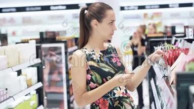 一个女孩的特写镜头来到香水和化妆品商店，选择一个<strong>化妆水</strong>，读瓶子上的标签
